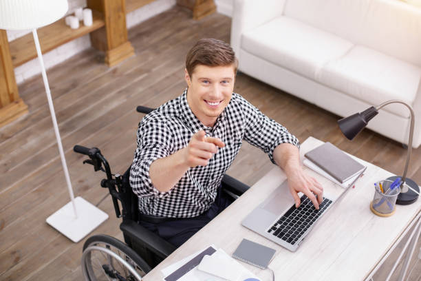 Watching you. Handsome man expressing positivity while being at work
